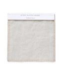 A square swatch of Fabric Swatch Natural Linen with stitched edges is shown on a white background, labeled jenni kayne home: Natural Linen, reflecting the refined style of Jenni Kayne furniture and Belgian flax linen.