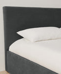 The Pacific Bed features an upholstered headboard and a white pillow, crafted from elegant Belgian linen.