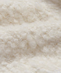 Close-up of the Fabric Swatch Ivory Wool Boucle, featuring a curly, looped surface in soft ivory. Its wool-like texture adds a cozy, inviting look—ideal for stylish upholstery projects.